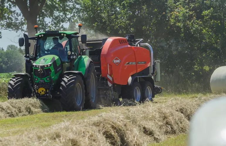 KUHN VBP 3260 baler-wrapper combination at work in a field full of wrapped bales.