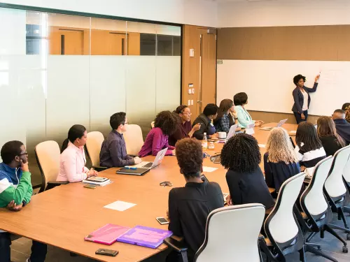 Formación empresarial con varios participantes alrededor de una mesa